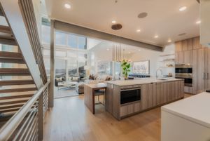 A bright kitchen with island and open living space.