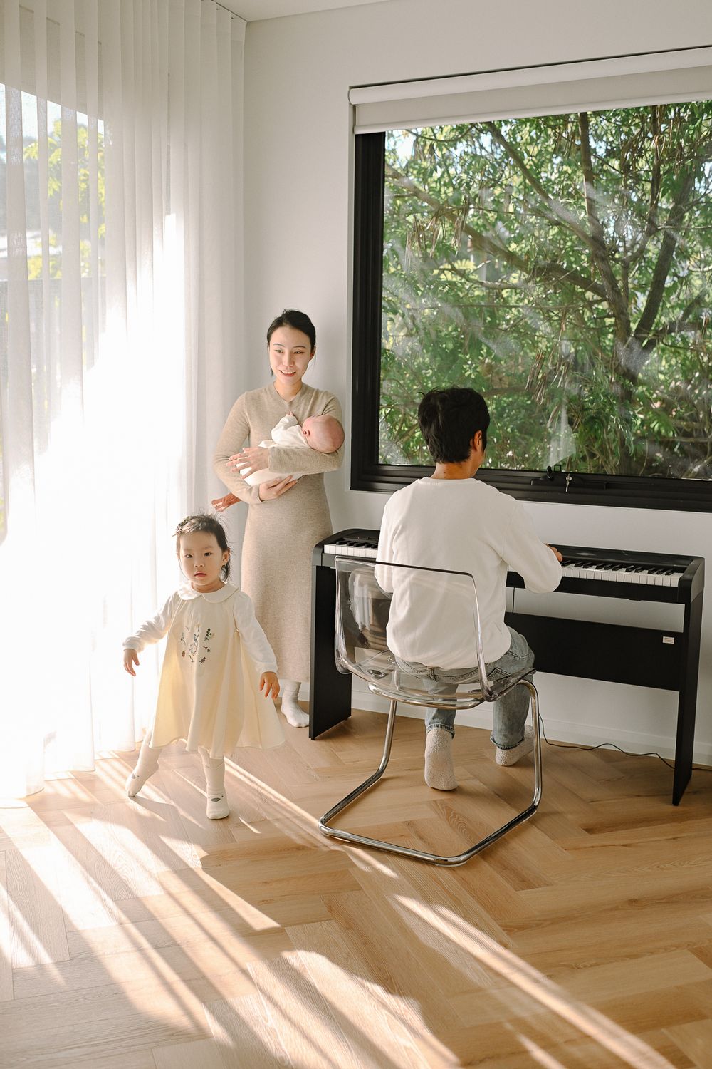 A series of five photos showing a dancer performing graceful movements in a bright room with a piano and hardwood floors.