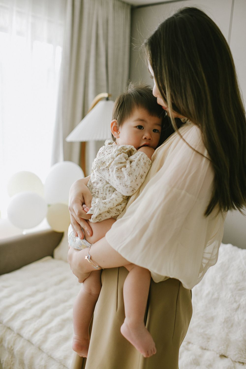 A tender moment between parent and child in a softly lit bedroom.