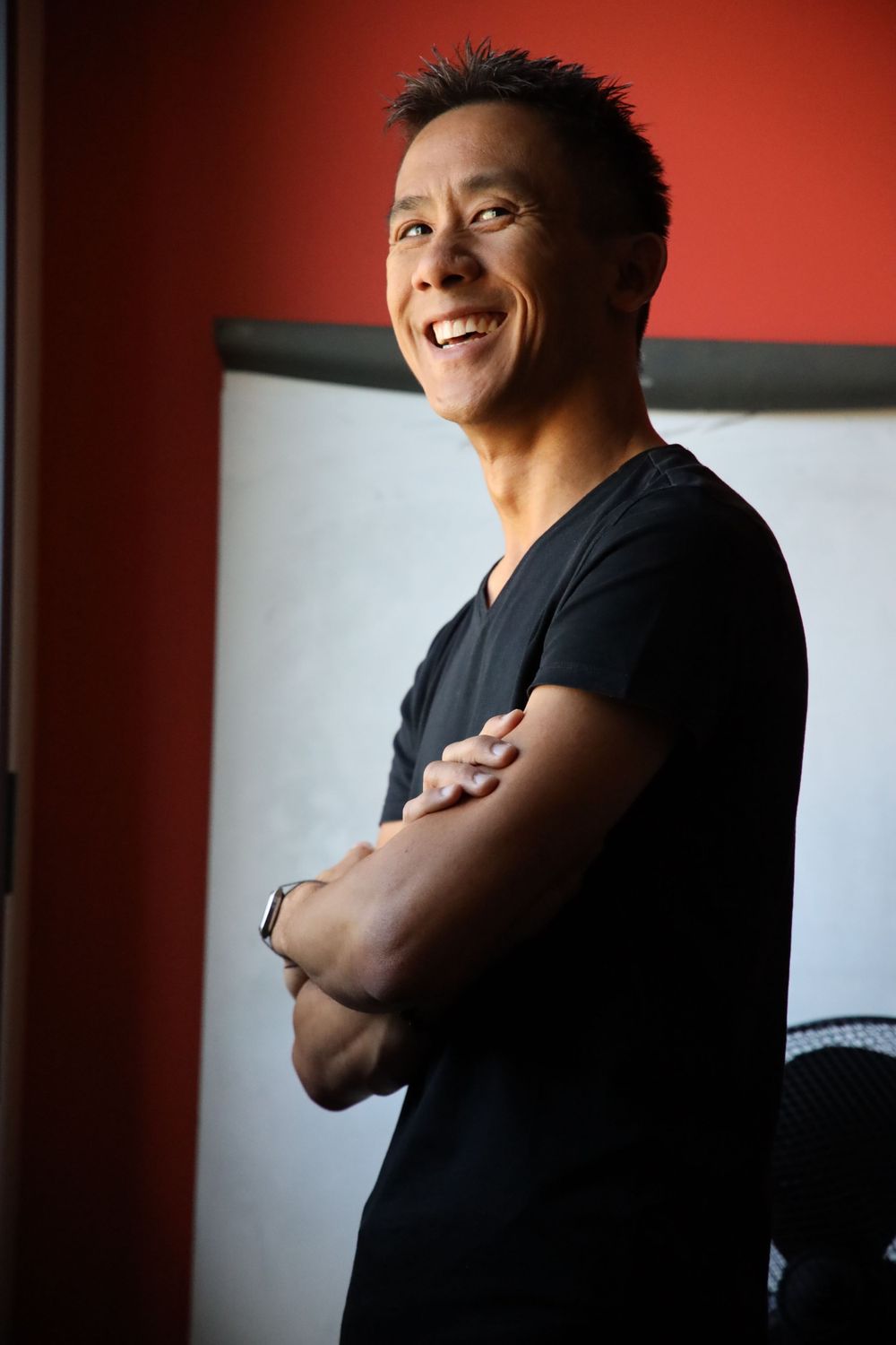 Portrait series against red wall showing progressive expressions and movement.