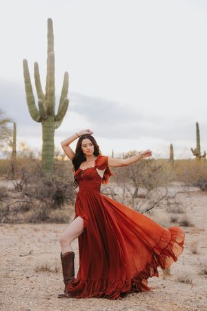 Artistic poses in a red flowing dress complement the desert's natural beauty.
