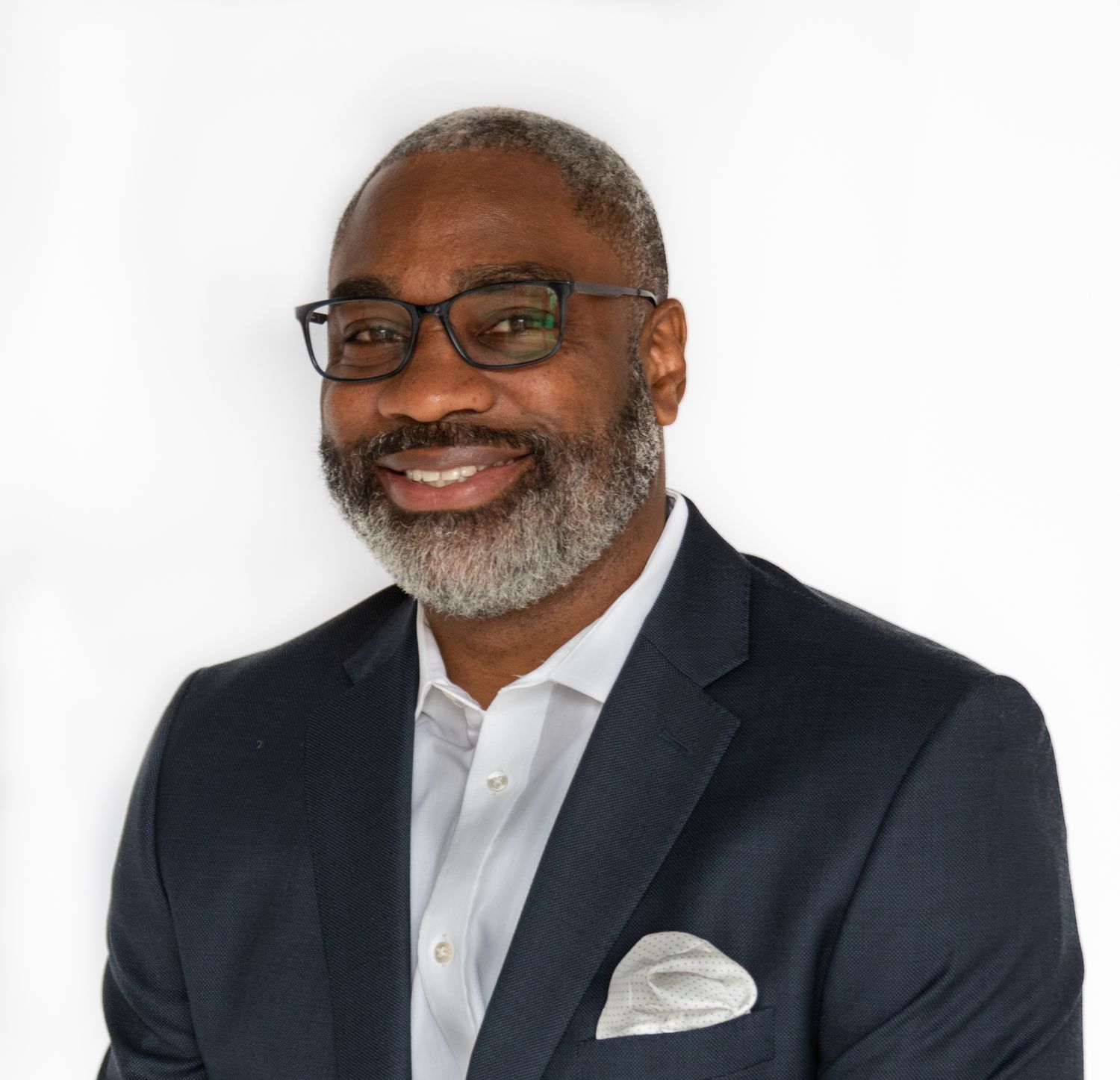 Professional headshot of a businessman in glasses and suit jacket with pocket square.
