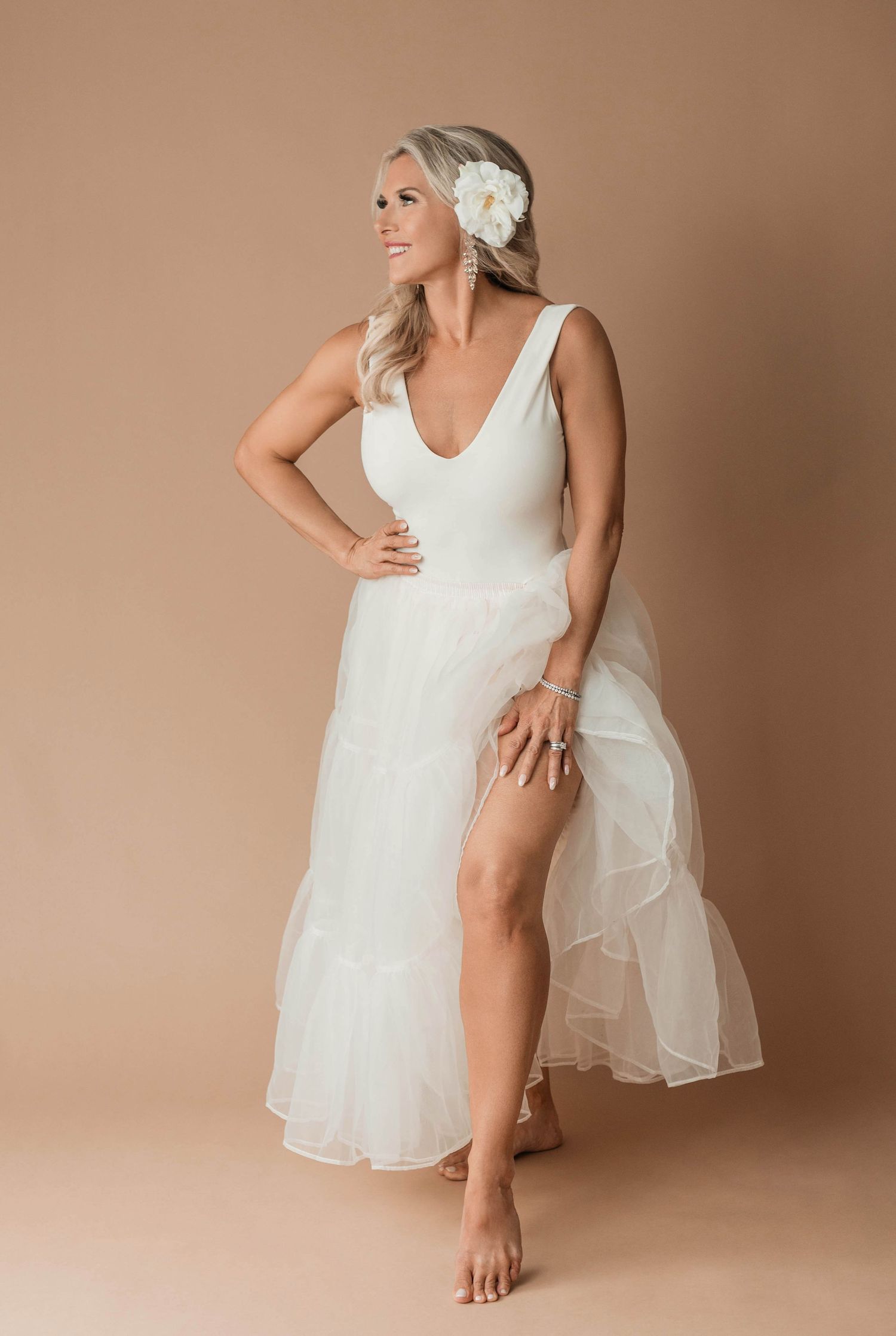 Artistic boudoir photography with white dress and floral hair accessory.