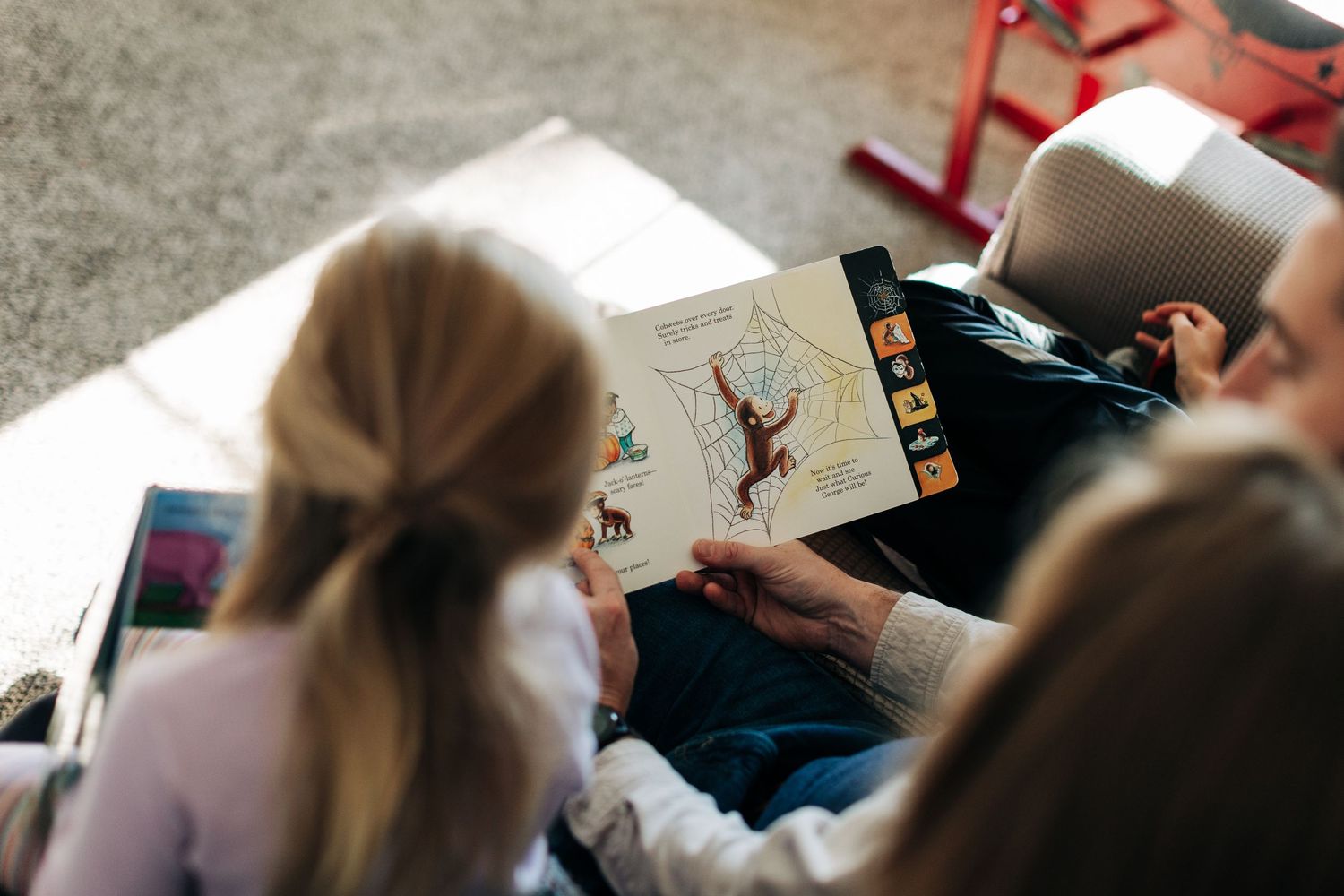 Children reading books and drawing while sitting on the floor together.