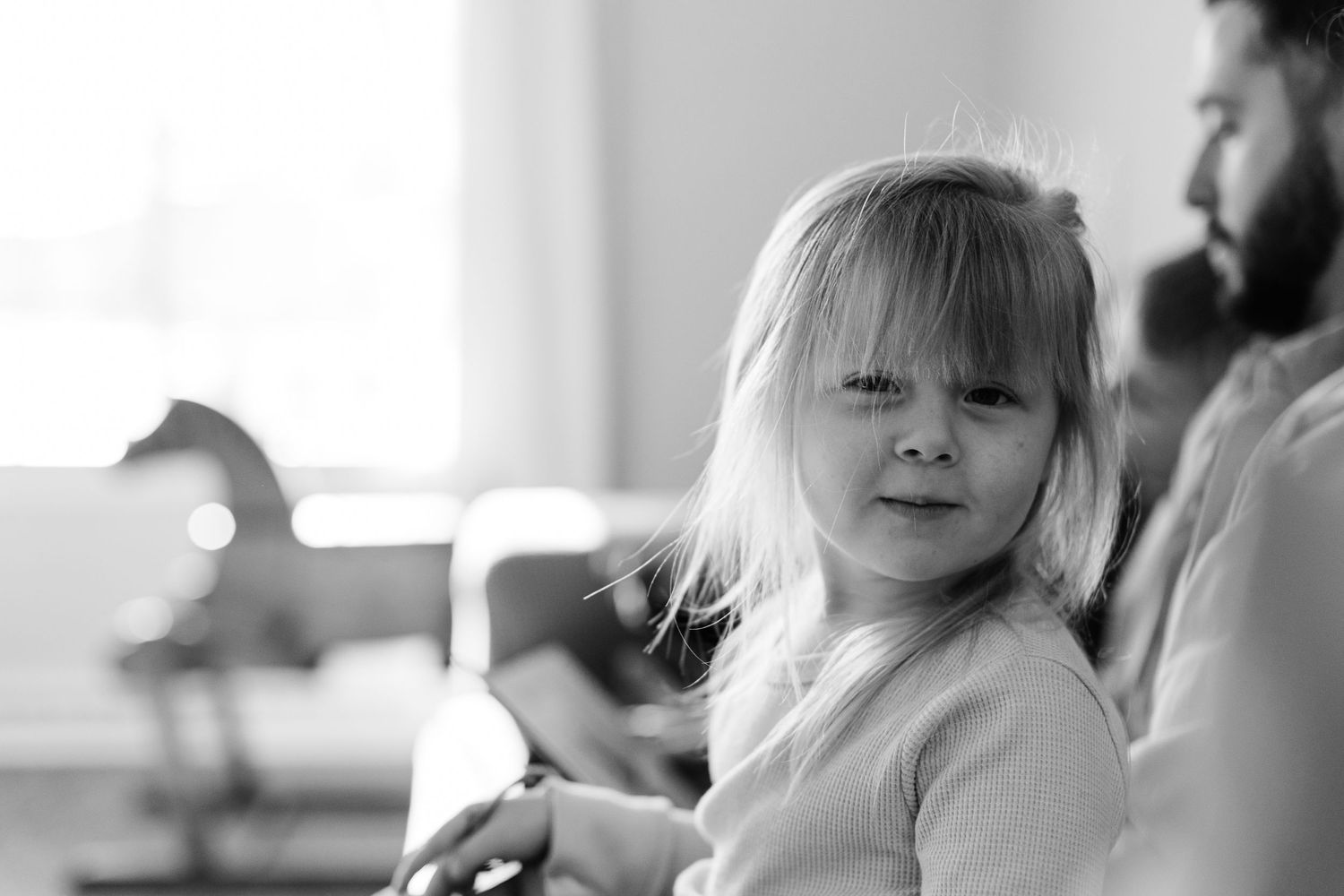 Candid black and white portrait in natural window light.