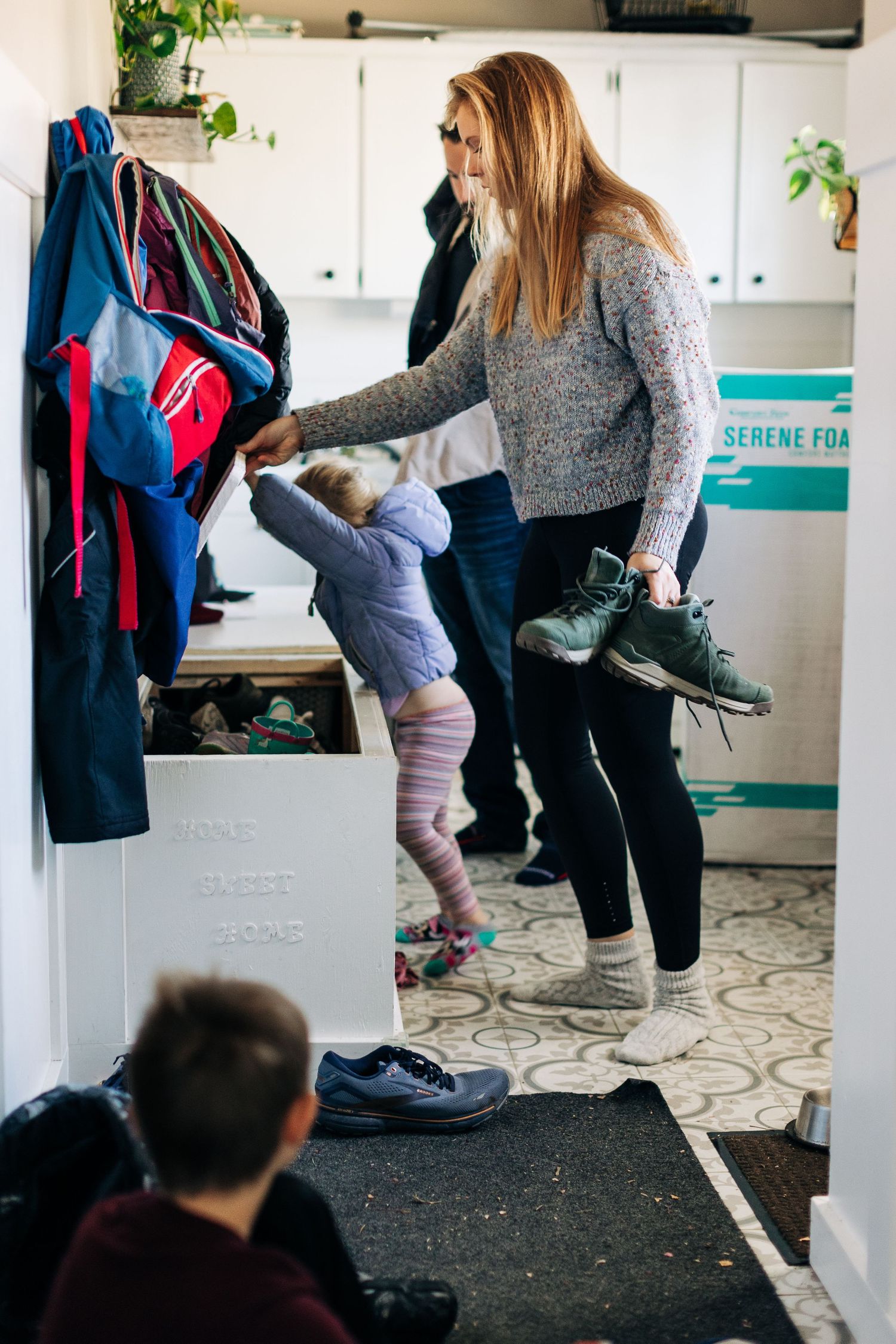 Getting ready in mudroom with backpacks and shoes organized by entryway.