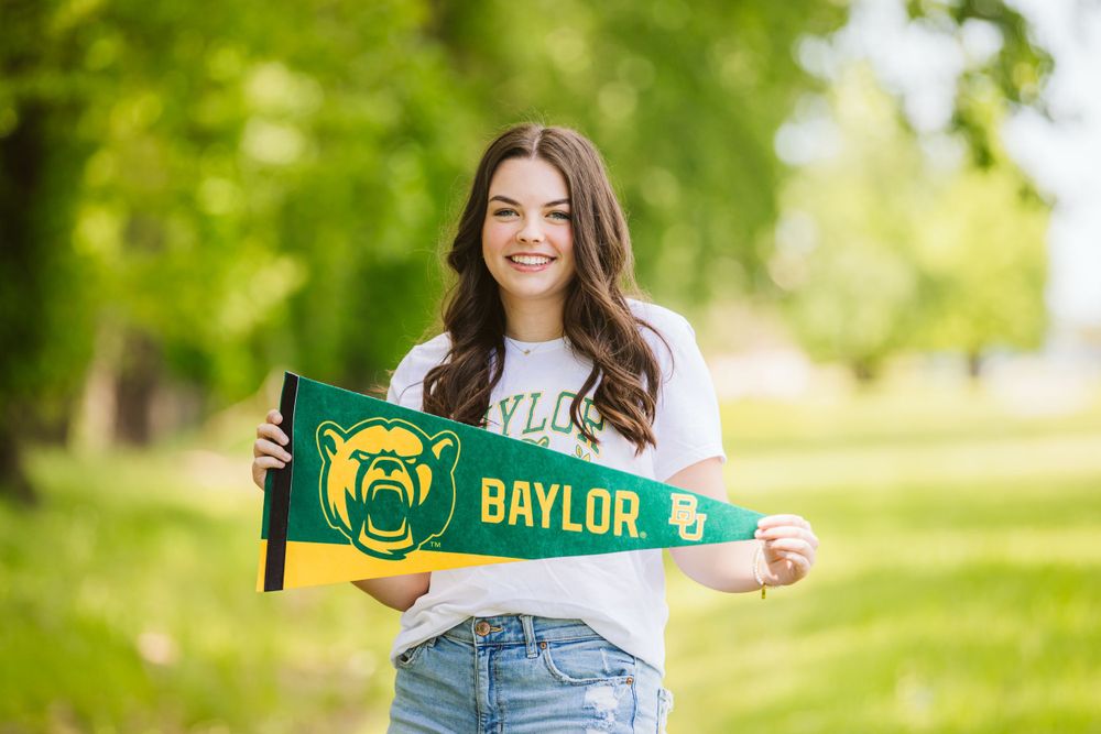 senior session of girl holding a pennant of baylor university