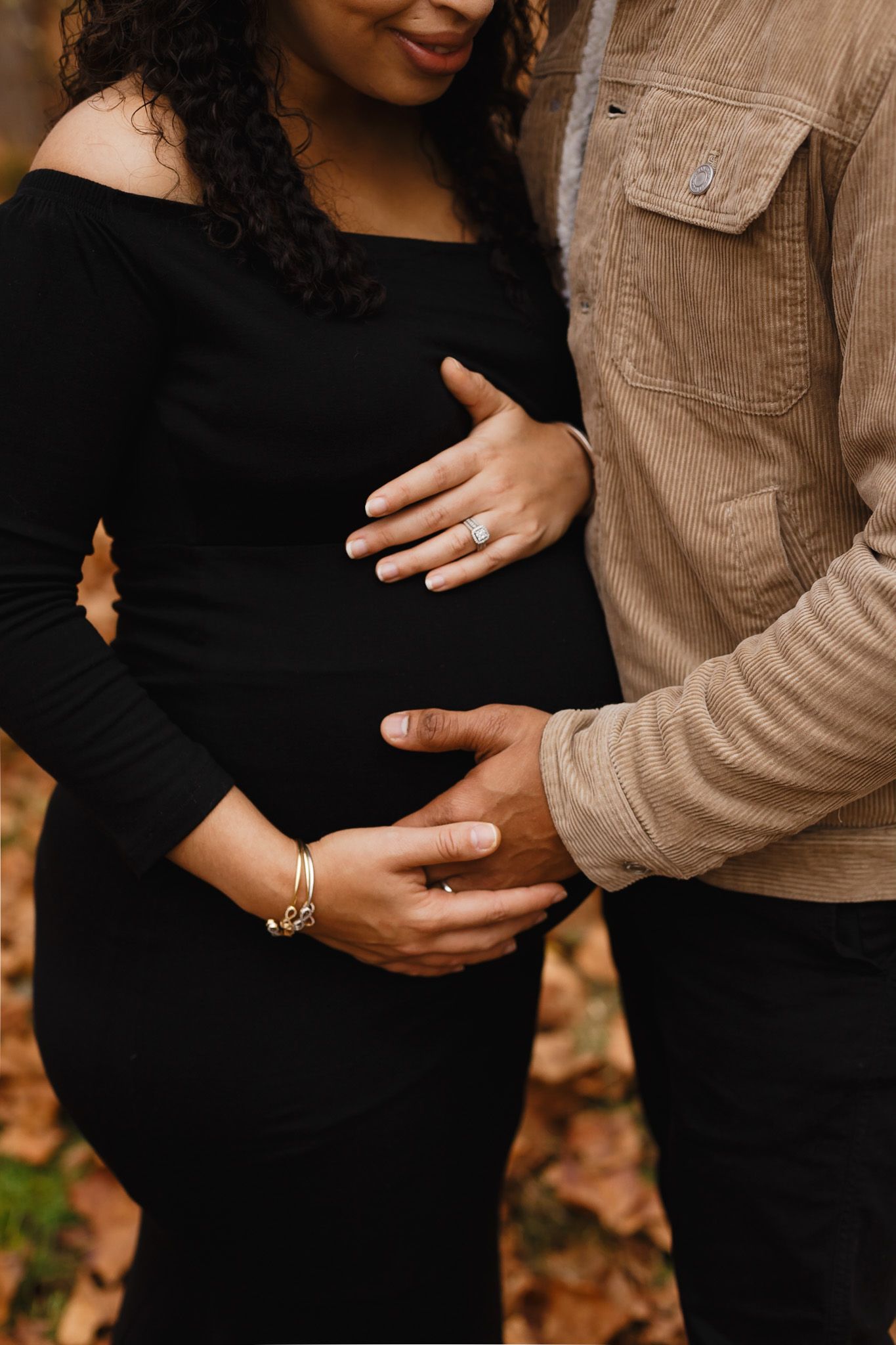 Expecting couple cradling the baby bump, maternity detail