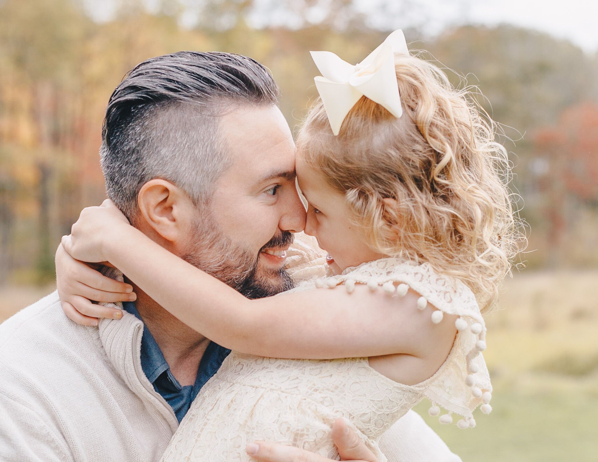 Father and daughter forehead to forehead in a Camp Hill field