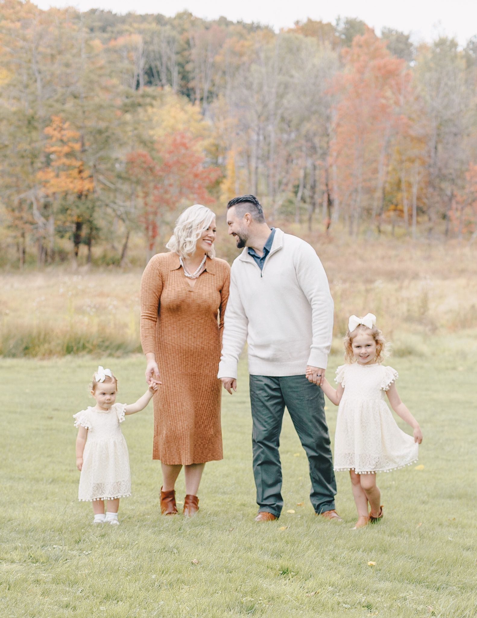 Family of four holding hands in an autumn field near Harrisburg