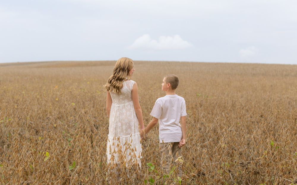 Mother and son holding hands in a wheat field in Mechanicsburg