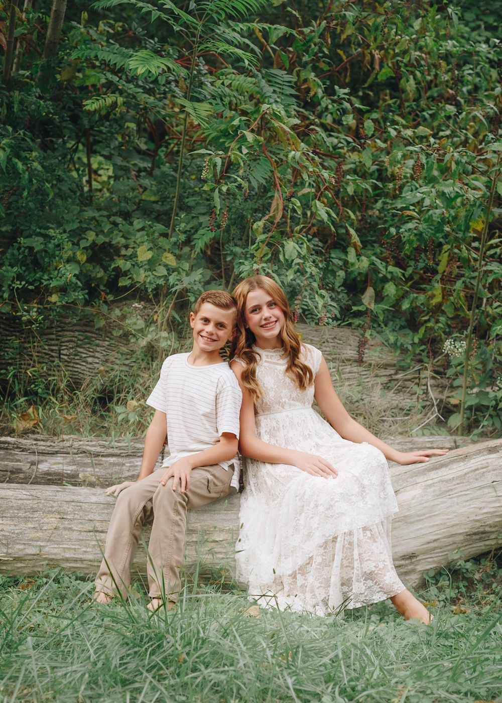 Mother and son sitting on a log among greenery in Camp Hill