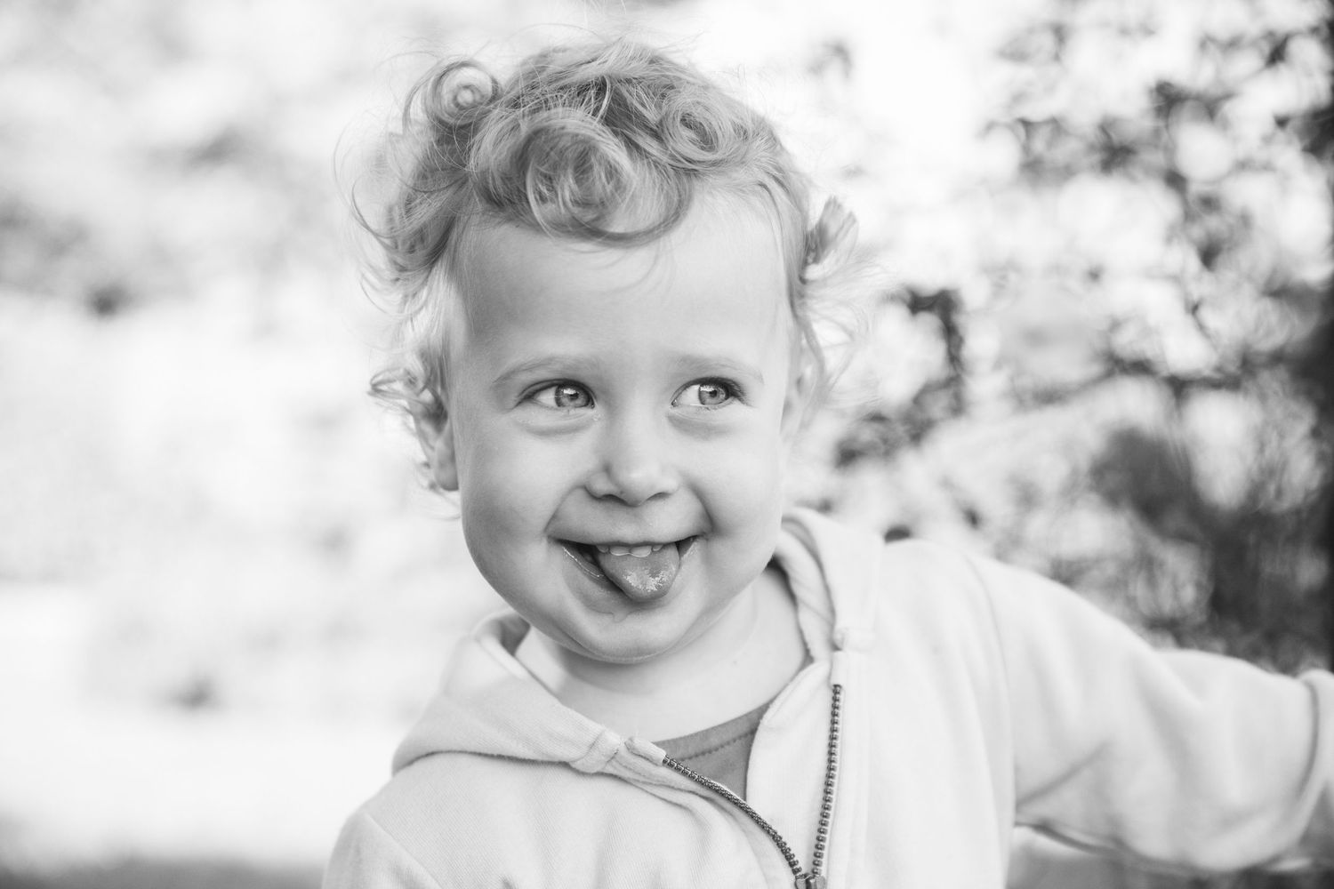 A black and white close-up portrait capturing pure happiness and genuine laughter.
