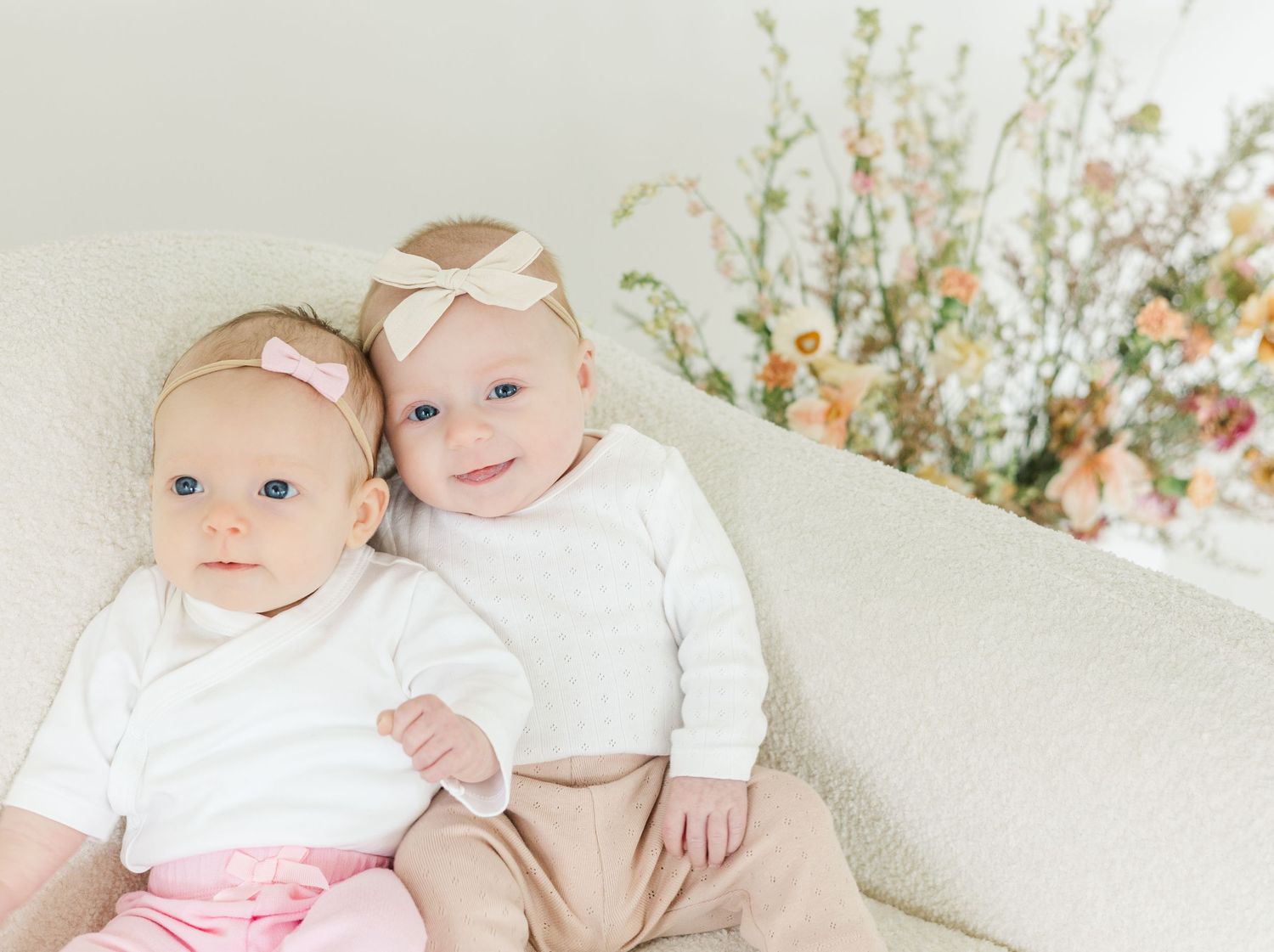 Gentle family moments captured in white studio with floral decorative elements.