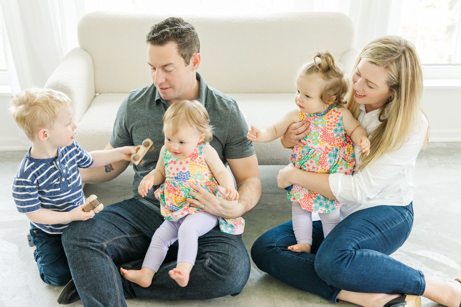 Candid family moments captured on white sofa during relaxed photo session.
