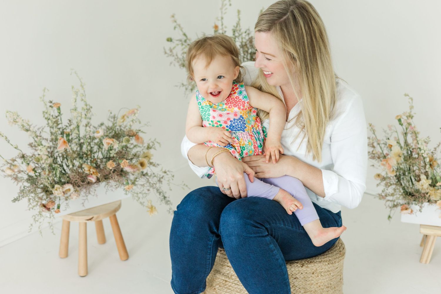 Casual family lifestyle photos captured in bright white studio with floral accents.
