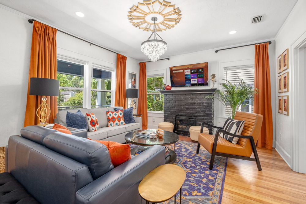 A professionally decorated living room with orange curtains in Gainesville, Fl.