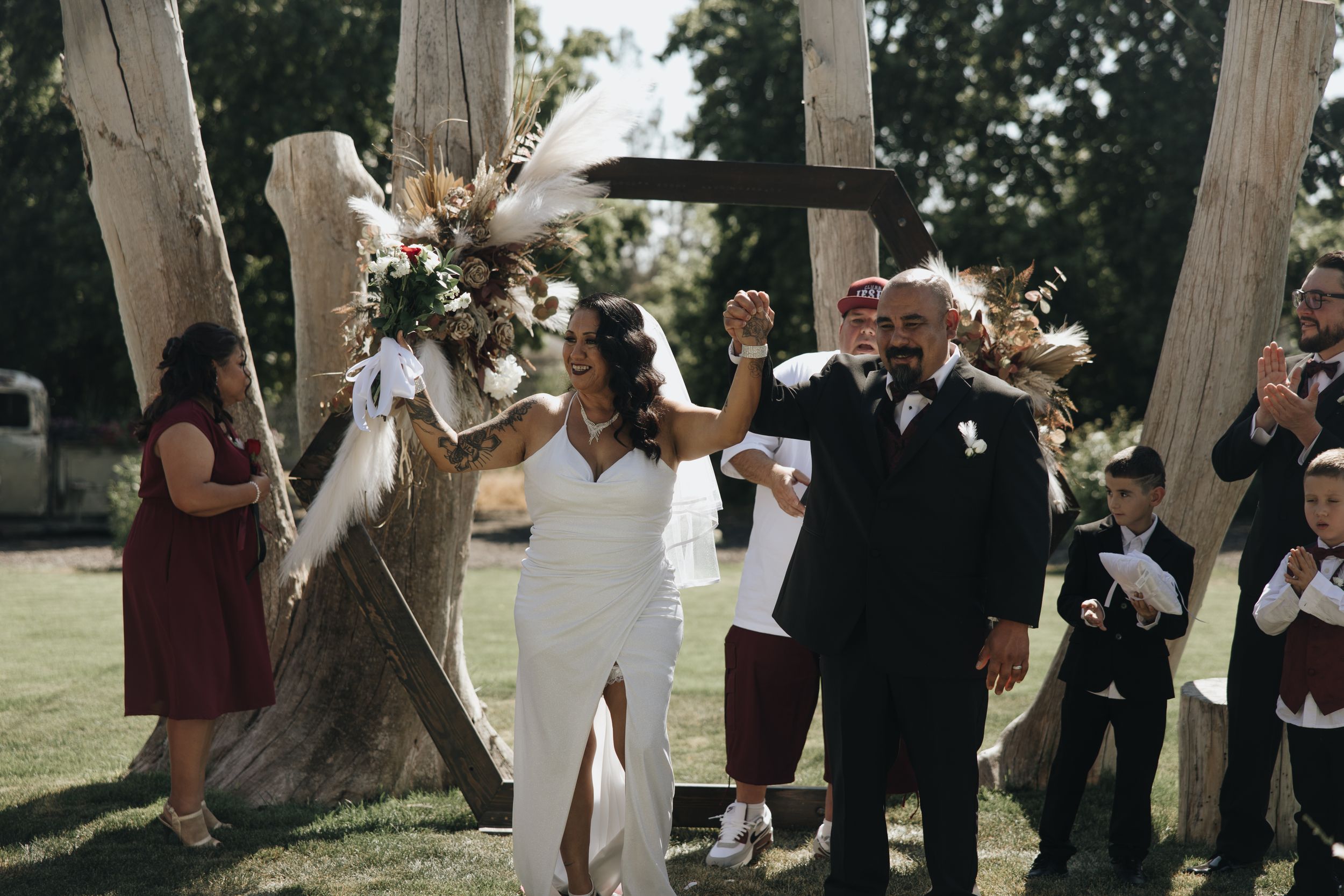 A celebratory moment at an outdoor wedding ceremony with dried flower arrangements.