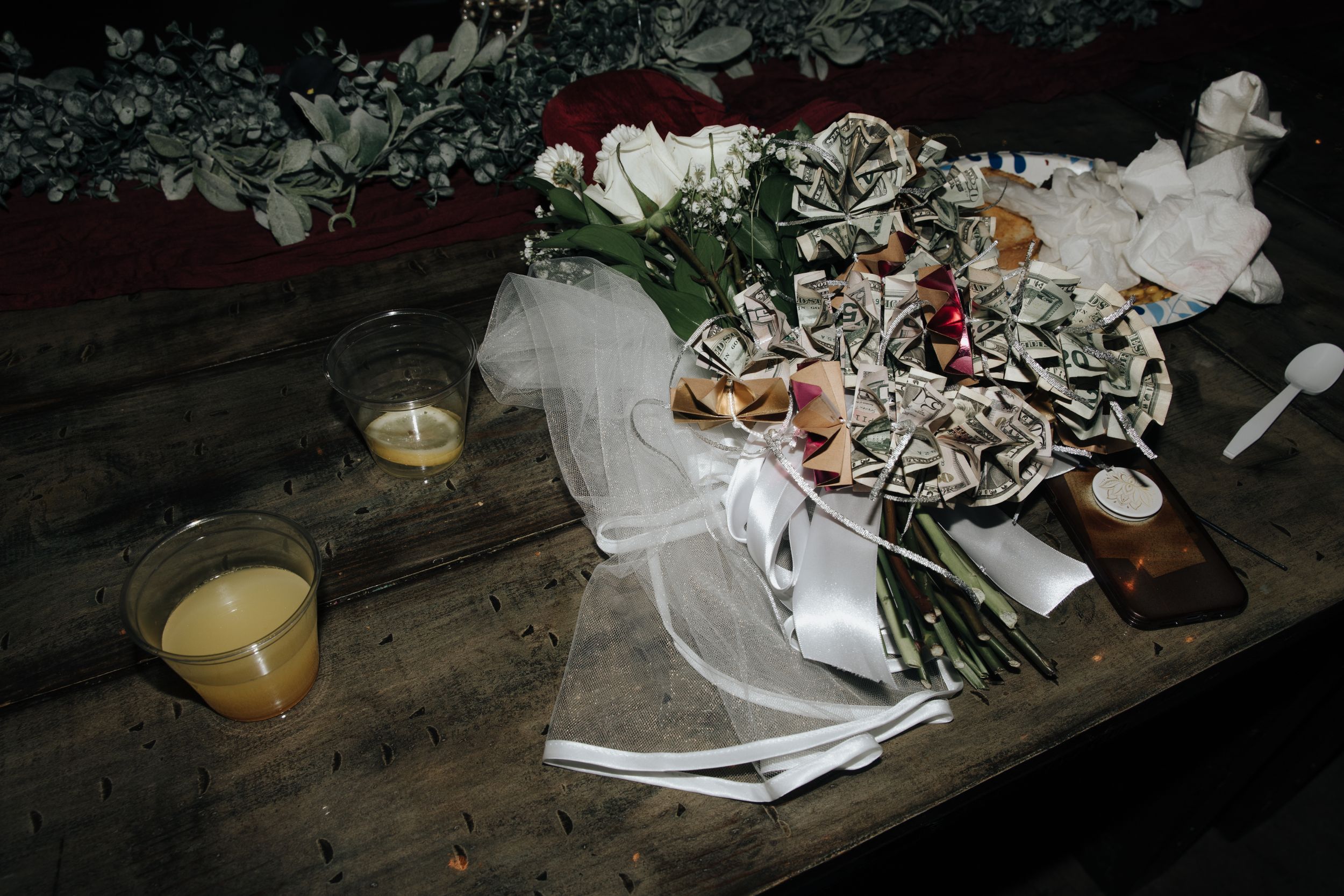 Rustic wedding decor with candles, flowers and lace details on wooden table.