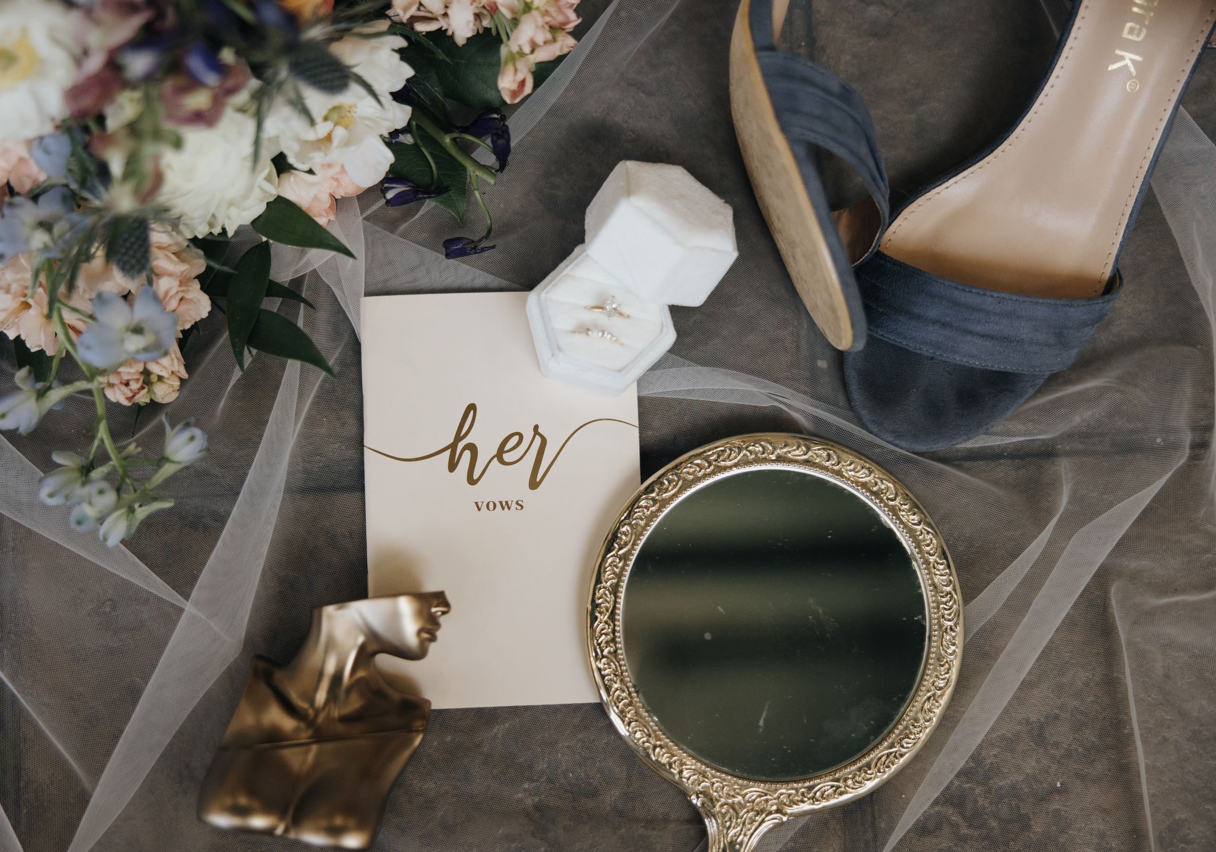 Wedding details flatlay with vintage mirror, shoes and 'her' sign.
