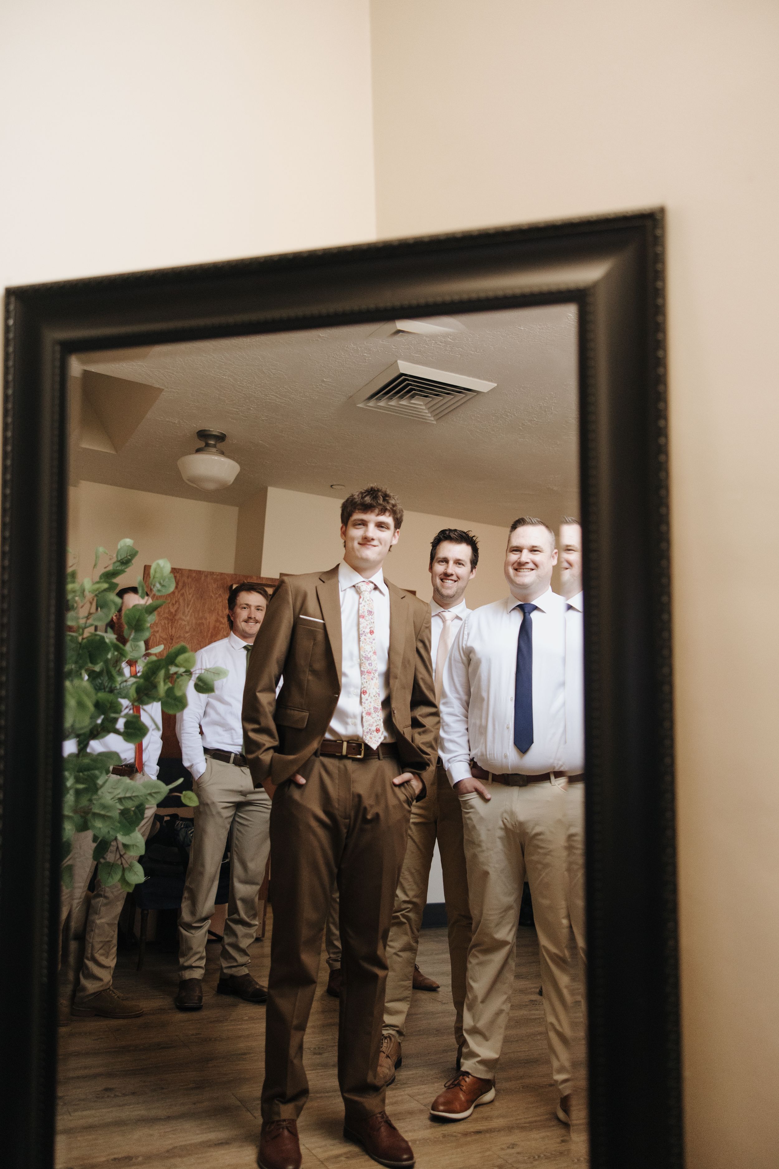 Mirror reflection of wedding party in formal attire.