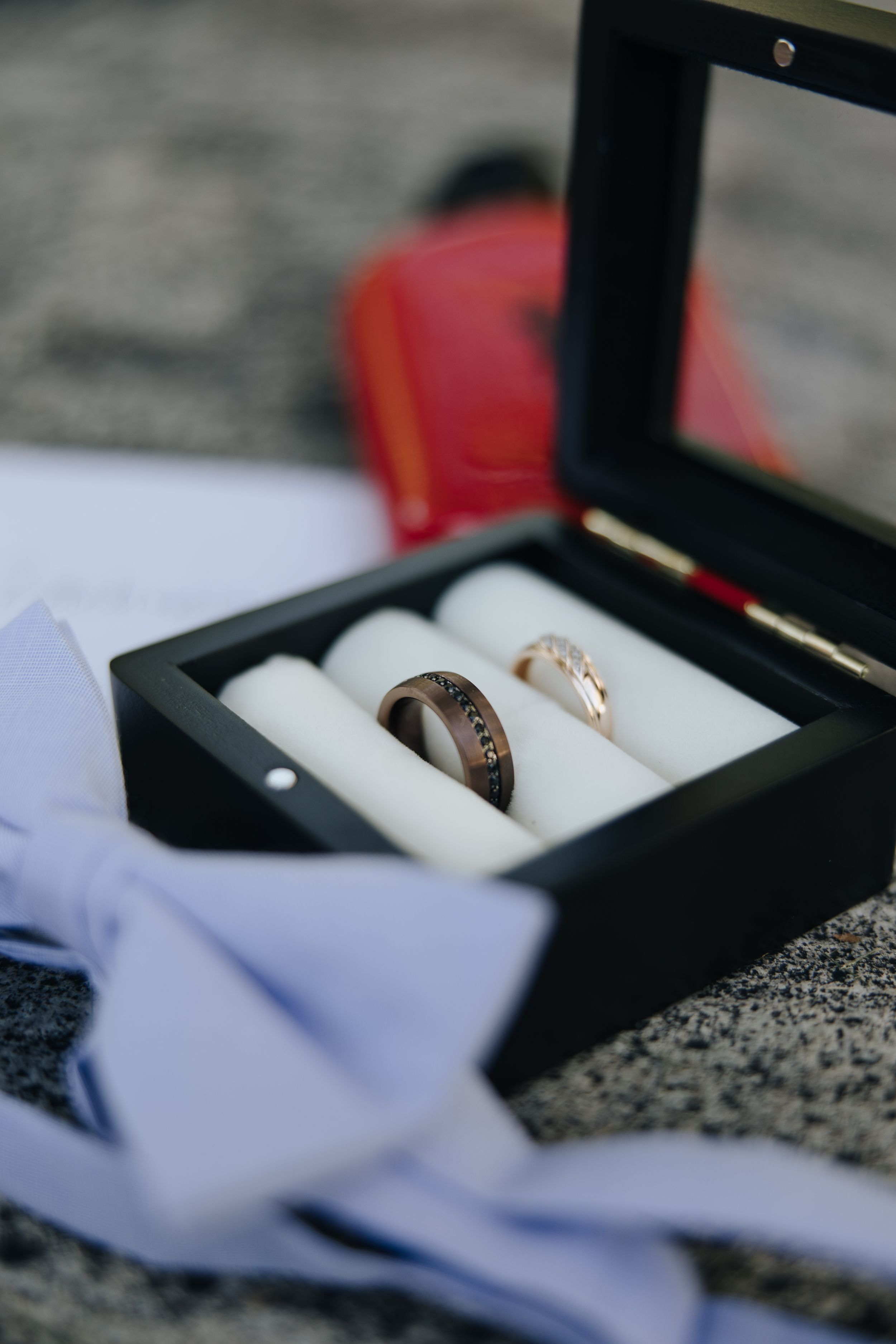 Two wedding rings displayed in a black jewelry box with white cushioning inserts.
