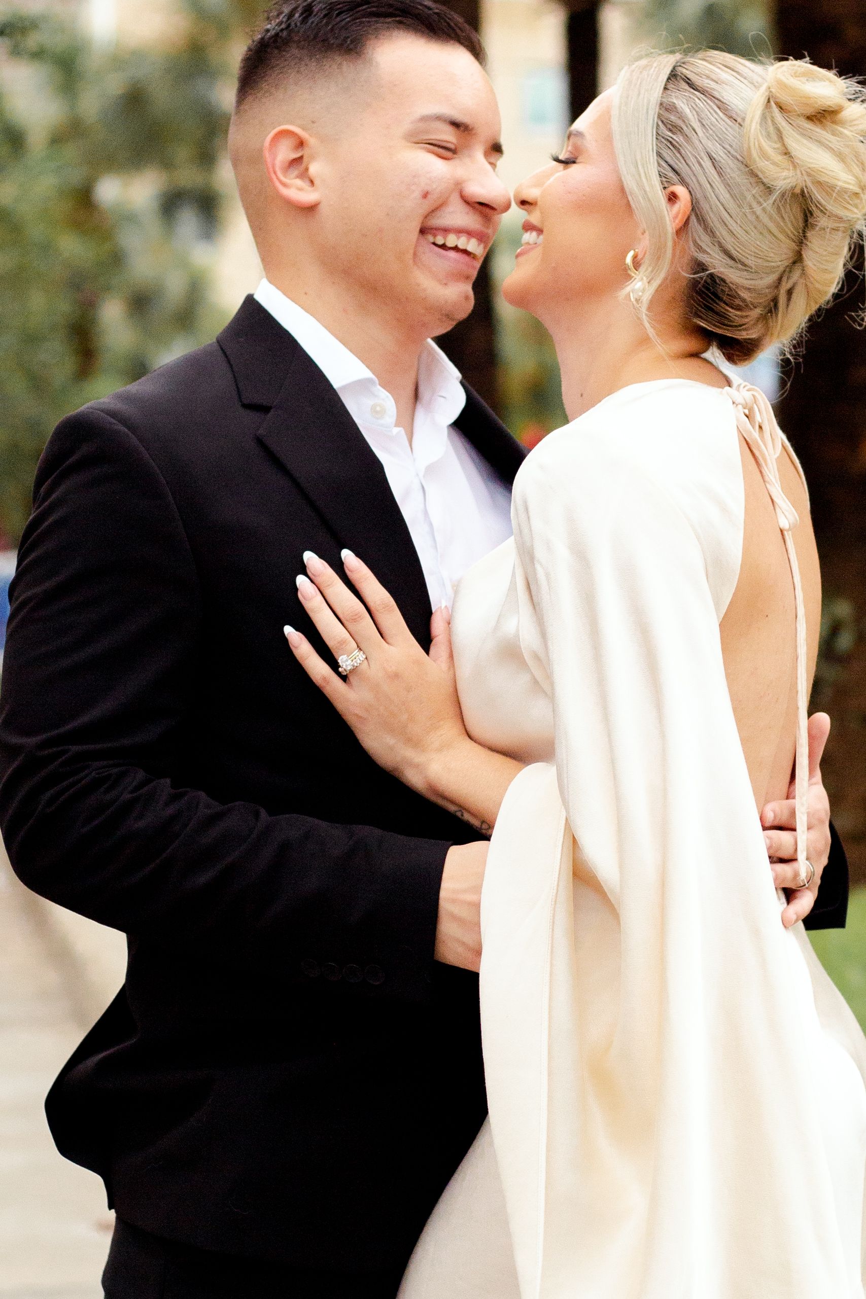 Intimate wedding portrait showing joyful laughter and embrace outdoors.