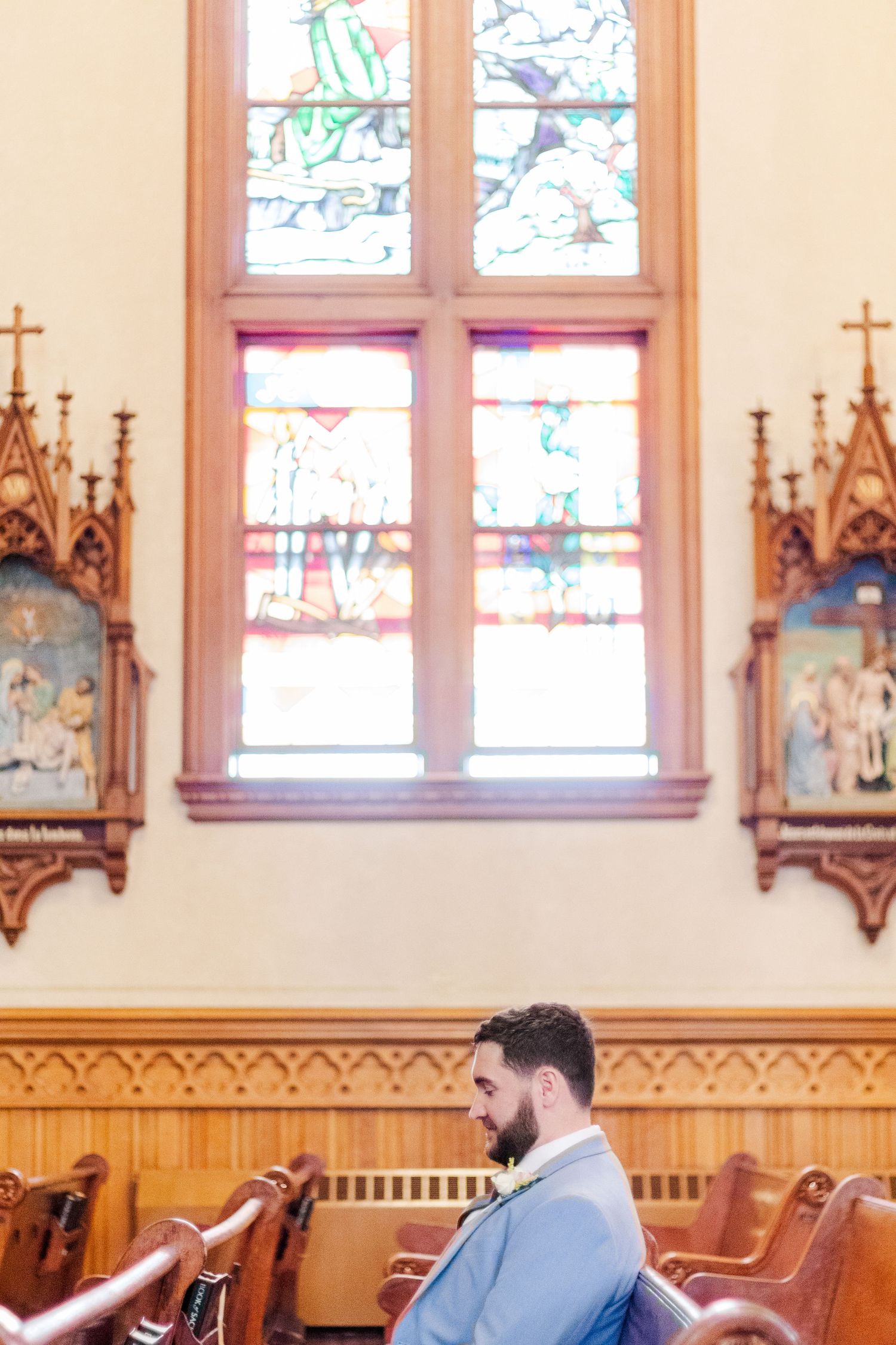 Interior of a church with stained glass windows and ornate wooden gothic details.
