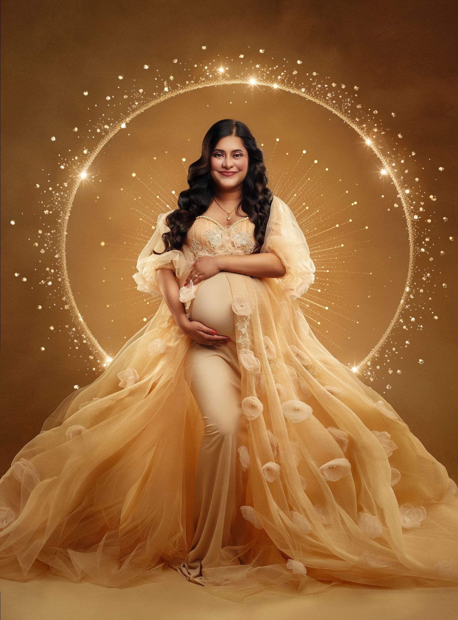 A maternity photoshoot featuring a flowing champagne-colored tulle gown against a warm sepia background with sparkling effects.