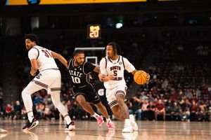 South Carolina Gamecocks player #5 dribbles past Mississippi State Bulldogs defender #10 during a college basketball game.