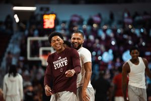 Two Mississippi State basketball players smiling and laughing together on the court during warm-ups.