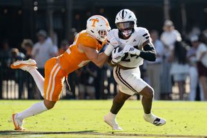 Football players dive and tackle during an intense play on the field.