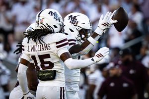 Football players battle for possession during a competitive college game.