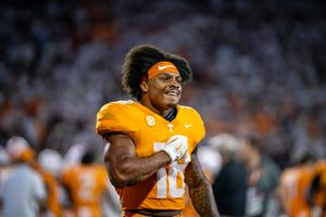 College football teams face off in a high-stakes match with orange uniforms visible.