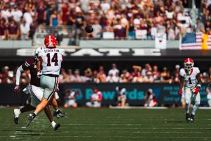 Wide view of football players spread across the field during gameplay.
