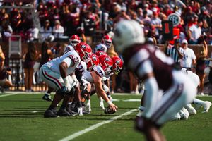 Football teams facing off at the line of scrimmage during a game.