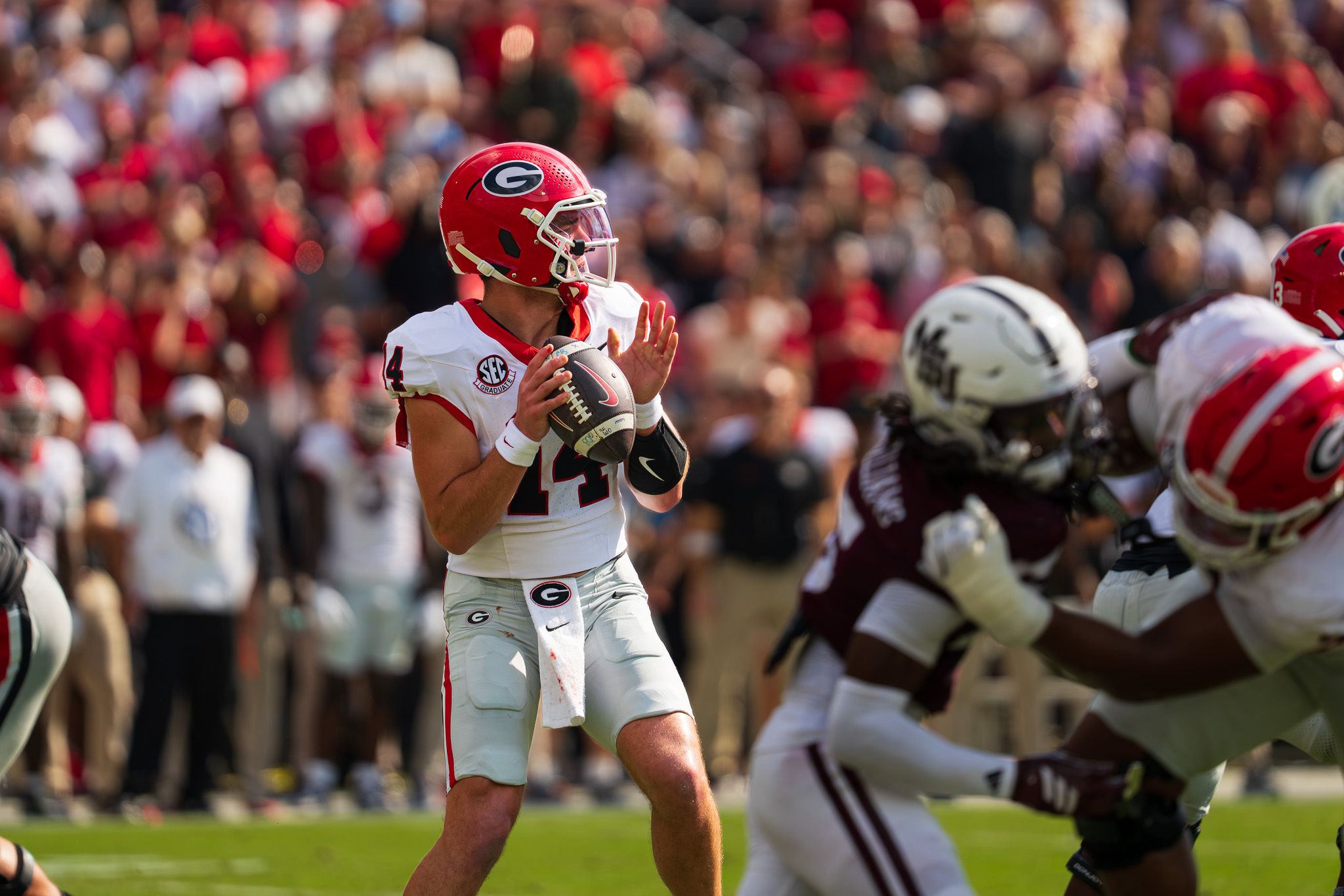 Football players from opposing teams engaged in gameplay on the field.