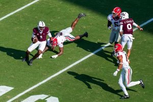 Dynamic action shot of football players during a running play on the field.