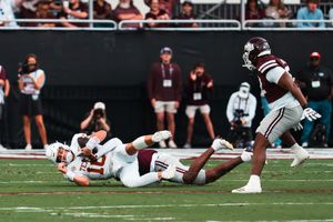 Football players diving and tackling during an intense game play.