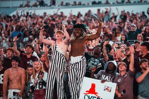 Enthusiastic crowd and referees react during an exciting moment at a football game.