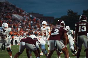 Football teams line up at the line of scrimmage during a tense game moment.