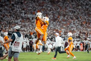 Football players from Tennessee and their opponents engage at the line before the snap.