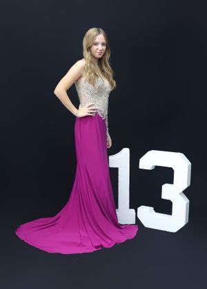 Formal portrait with sparkly silver top and flowing magenta dress next to number 13.