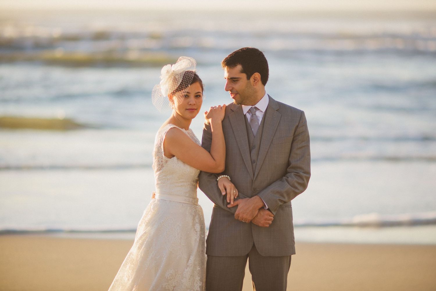 Romantic beachside wedding couple portrait at sunset.