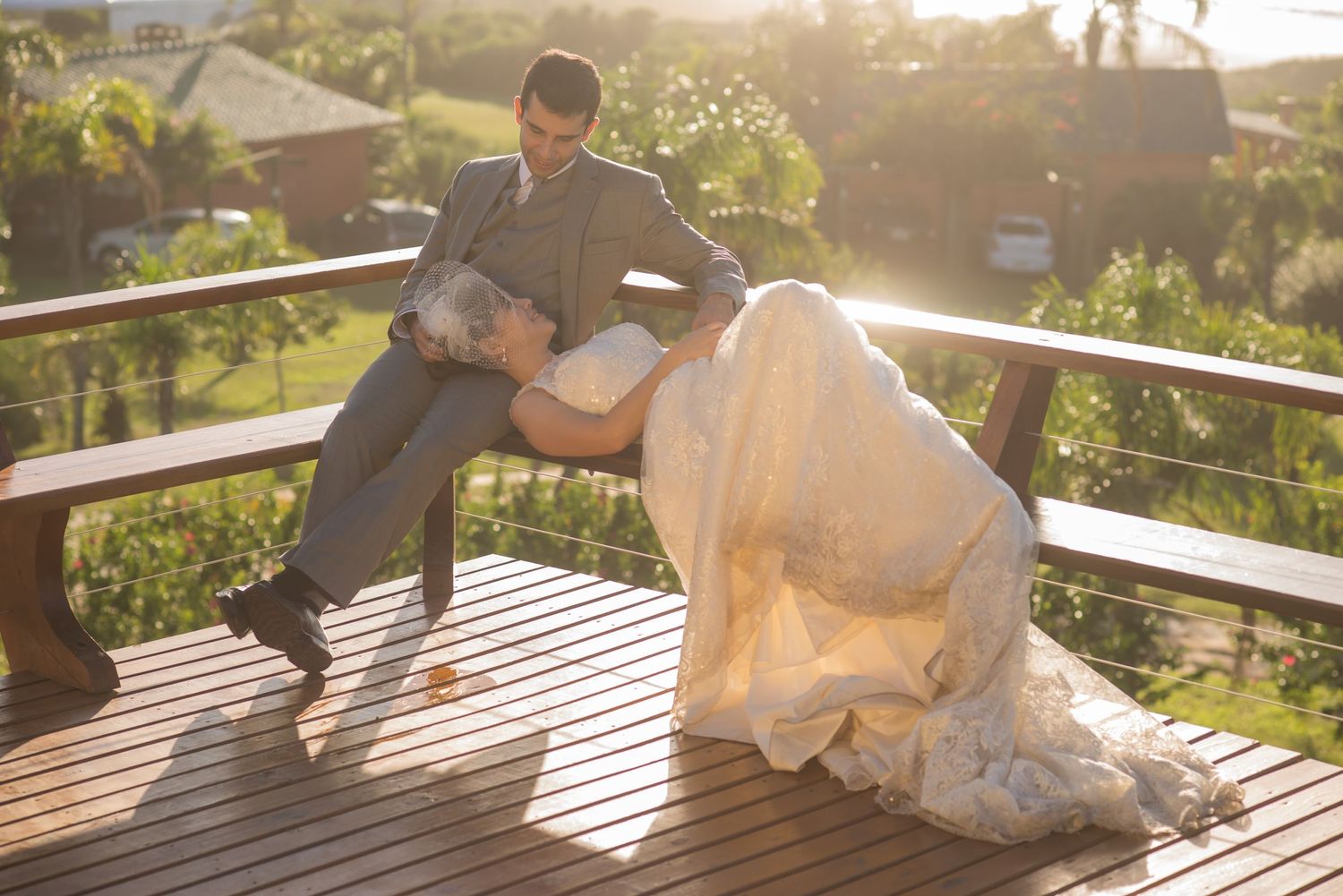 Dreamy sunlit portrait on wooden deck with tropical garden backdrop.