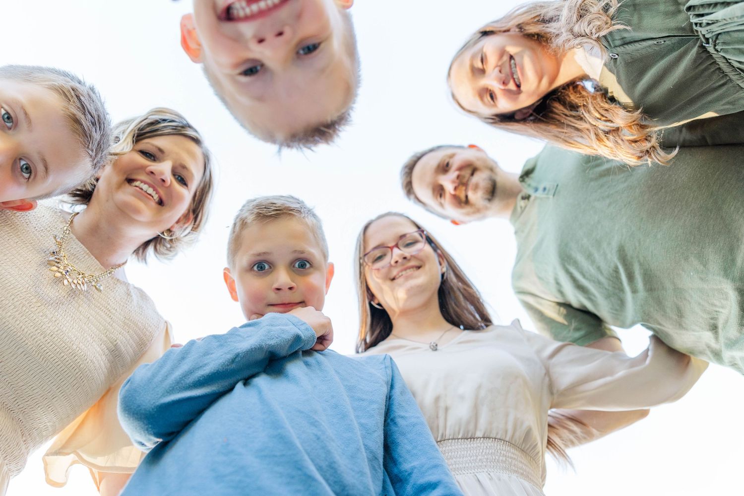 Happy group of children forming a circle and smiling down at the camera from above.
