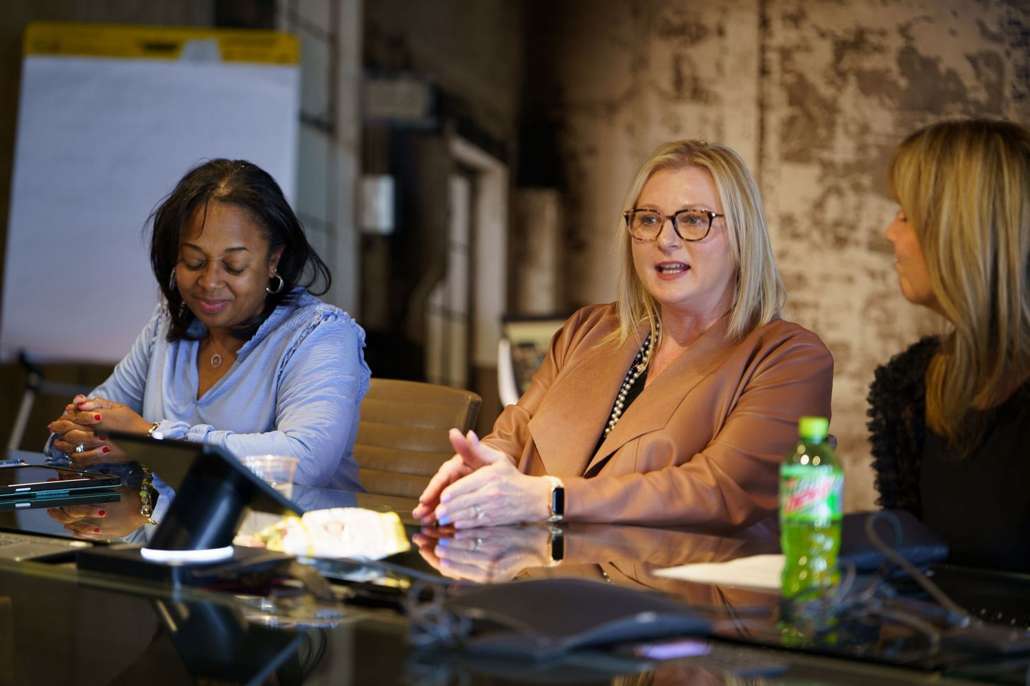 Group of people sitting at a conference table in a dimly lit meeting room.