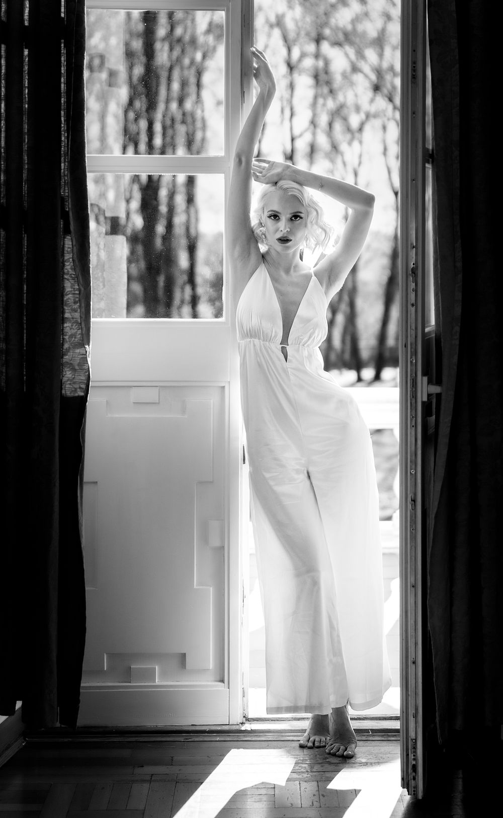 Black and white artistic portrait by a sunlit window. sesja ślubna, przygotowania