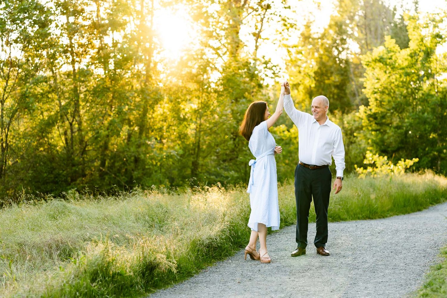 Husband twirling wife in a field in Seattle.