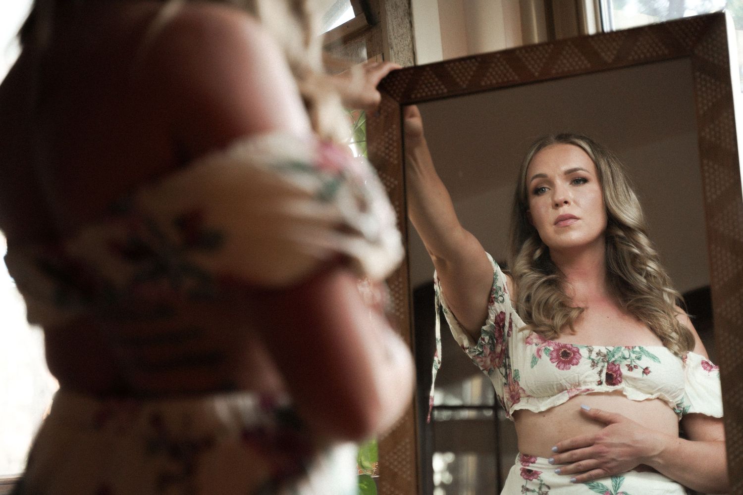Artistic portrait photography featuring woman in floral dress with mirror reflection.